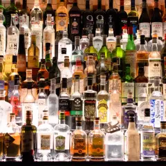 Różnorodne butelki alkoholi, od wódki po likiery. Zastanawiasz się, ile kalorii ma pół litra wódki?
