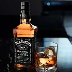 Butelka Jack Daniel's Tennessee Whiskey i szklanka z lodem. Idealny sposób, jak pić Jacka Danielsa, by docenić jego smak.