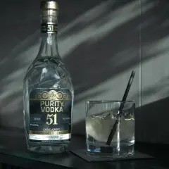 Butelka Purity Vodka i szklanka z drinkiem. Wódka, okowita i bimber – definicje prawne.