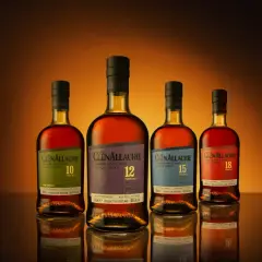 Cztery butelki whisky GlenAllachie, od 10 do 18 lat, z wyblakłymi etykietami, ukazujące skutki trzymania butelki whisky w nasłonecznionym miejscu.