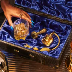 Skutki zbyt niskiej temperatury serwowania: dlaczego nie mrozić whisky. Elegancki zestaw z butelką Chivas Regal 18, szklanką z lodem i złotymi akcesoriami.