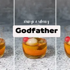 Klasyczny drink "Godfather" z amaretto i szkocką whisky, ozdobiony wiśnią i lodem.