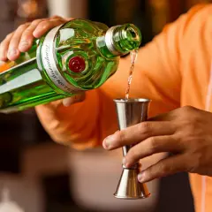 Barman nalewa gin do jiggera. Standardowy shot to 45 ml, a jigger barmański ma proporcje 25/50 ml.
