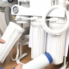 Wymiana filtra węglowego w domowym systemie filtracji wody. Widoczne objawy przesycenia węglem aktywnym, wskazujące na potrzebę serwisu.