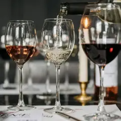 Degustacja win: ile kalorii ma kieliszek białego wina, a ile czerwonego i różowego? Kieliszki z winem białym, różowym i czerwonym na stole.