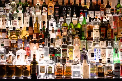 Różnorodne butelki alkoholi, od wódki po likiery. Zastanawiasz się, ile kalorii ma pół litra wódki?