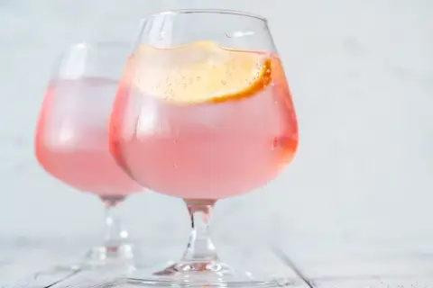 Dwa orzeźwiające drinki z plasterkiem cytryny. Czy wódka tuczy? Te różowe napoje wyglądają kusząco, ale warto pamiętać o kaloriach.