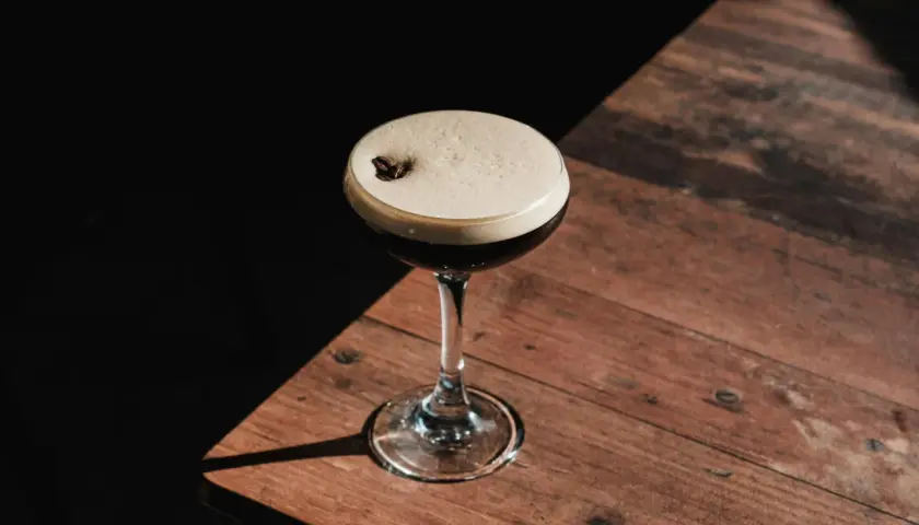 Espresso martini z gęstą, trwałą cremą, ozdobione ziarnem kawy. Idealny przepis na to, jak zrobić espresso martini, by uzyskać perfekcyjną piankę.