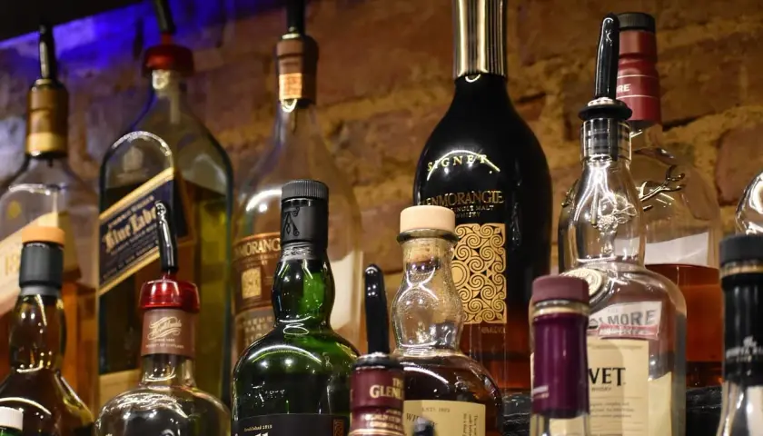 Butelki whisky na półce. Pionowe przechowywanie zapobiega objawy wyschnięcia korka.