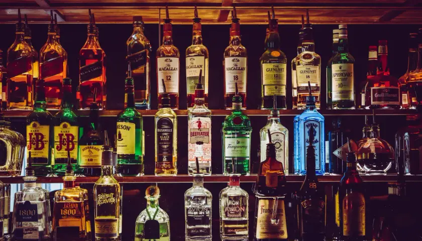 Rzędy butelek z whisky i innymi alkoholami. Zastanawiasz się, ile kropel wody dodać do whisky, by "otworzyć" jej aromat i smak?