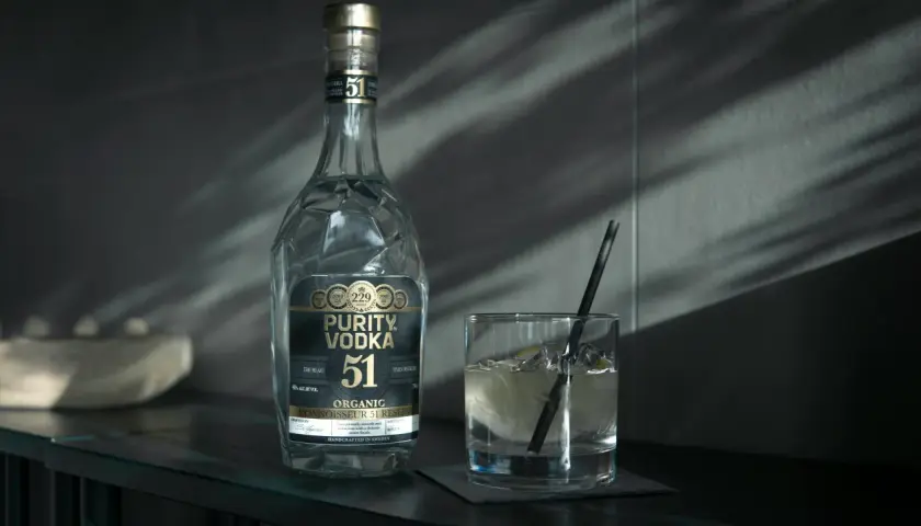 Butelka Purity Vodka i szklanka z drinkiem. Wódka, okowita i bimber – definicje prawne.