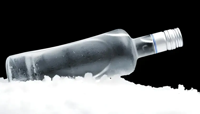 Butelka wódki w lodzie, ilustrująca, dlaczego wódka nie zamarza w domowej zamrażarce – fizyka alkoholu.