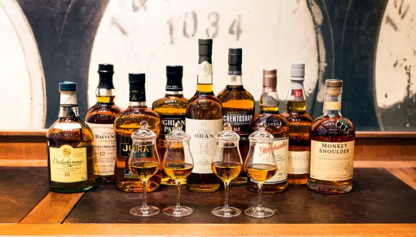 Rząd butelek whisky, w tym Dalwhinnie 15, Balvenie 12, Jura, Oban, Glenmorangie, Monkey Shoulder. Czy warto kupować whisky bez określenia wieku (NAS)?