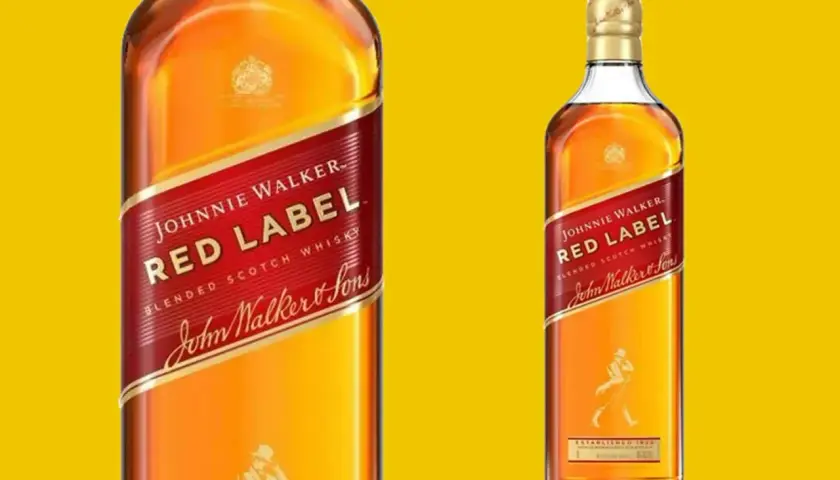 Dwie butelki whisky Johnnie Walker Red Label na żółtym tle. Klasyczna, rozpoznawalna etykieta z czerwonym pasem i postacią spacerowicza.
