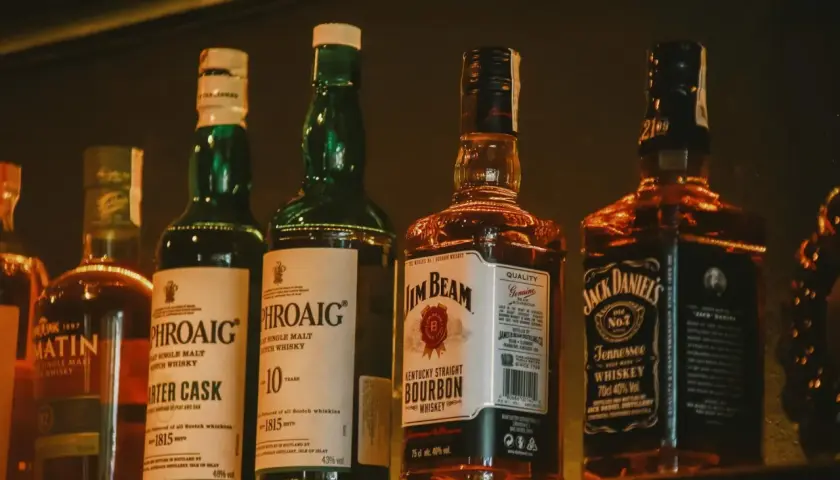 Butelki whisky: różnice w kolorze, od naturalnej barwy po karmel E150a.