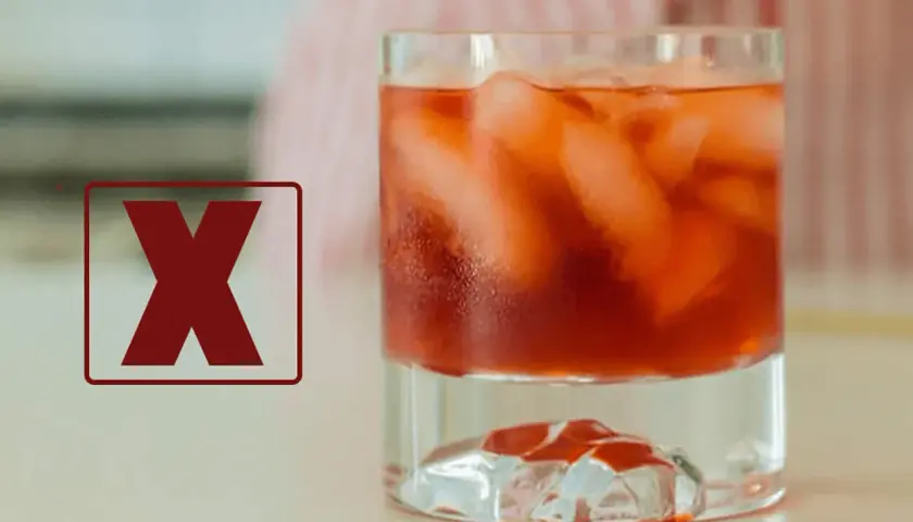 Czerwony znak "X" obok drinka z lodem. Dlaczego negroni musi być mieszane, a nie wstrząsane w shakerze, by zachować idealny smak.
