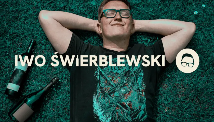 Przyczyny "łez" na ściankach kieliszka mówią o zawartości alkoholu. Mężczyzna leży na trawie obok butelek.