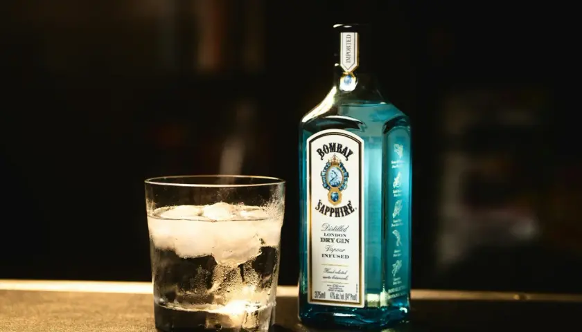 Szklanka z lodem i butelka ginu Bombay Sapphire. Tani tonik do rzemieślniczego ginu to strata aromatu, gin traci swój charakter.