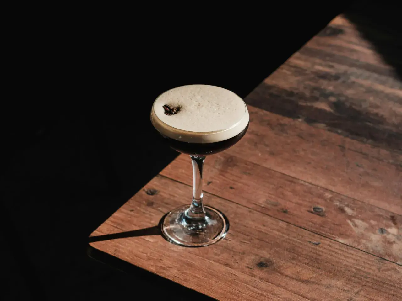 Espresso martini z gęstą, trwałą cremą, ozdobione ziarnem kawy. Idealny przepis na to, jak zrobić espresso martini, by uzyskać perfekcyjną piankę.