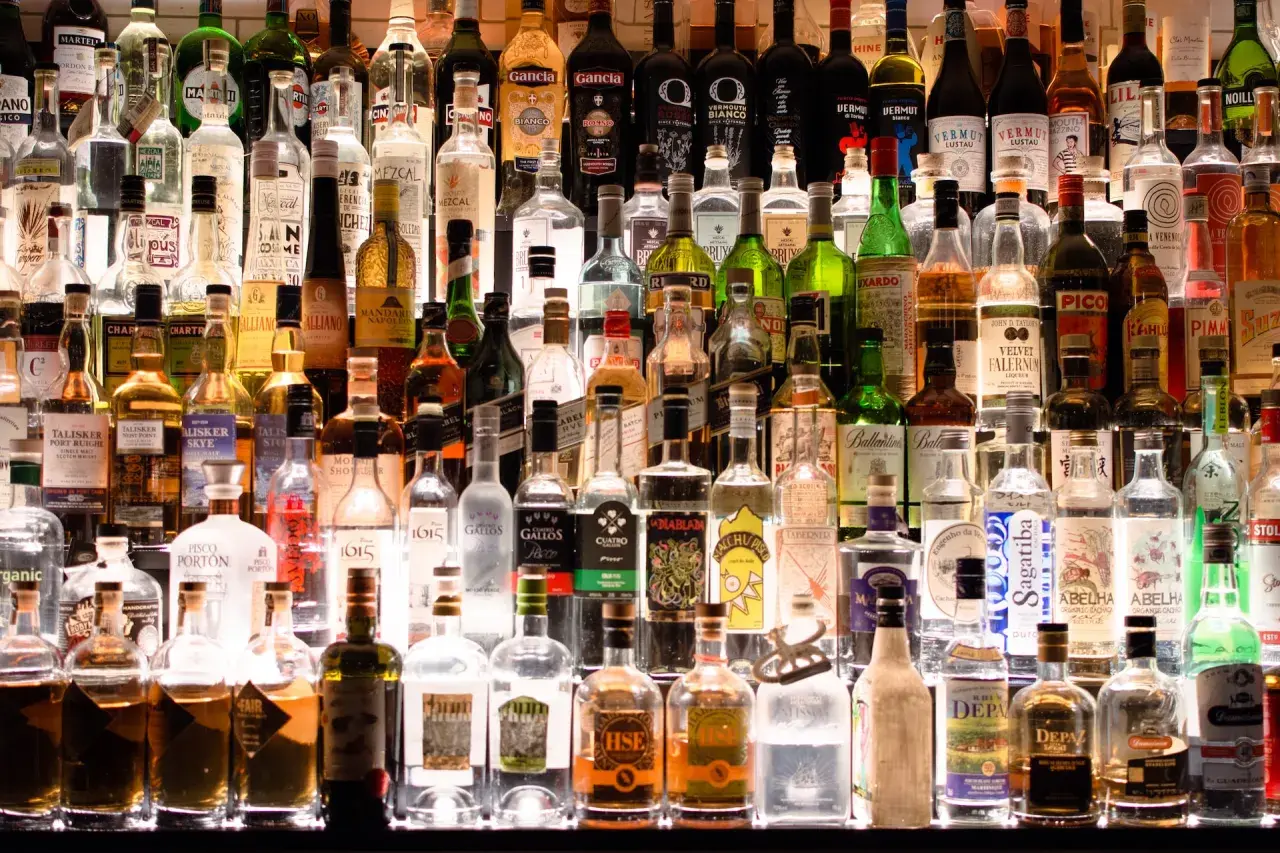 Różnorodne butelki alkoholi, od wódki po likiery. Zastanawiasz się, ile kalorii ma pół litra wódki?