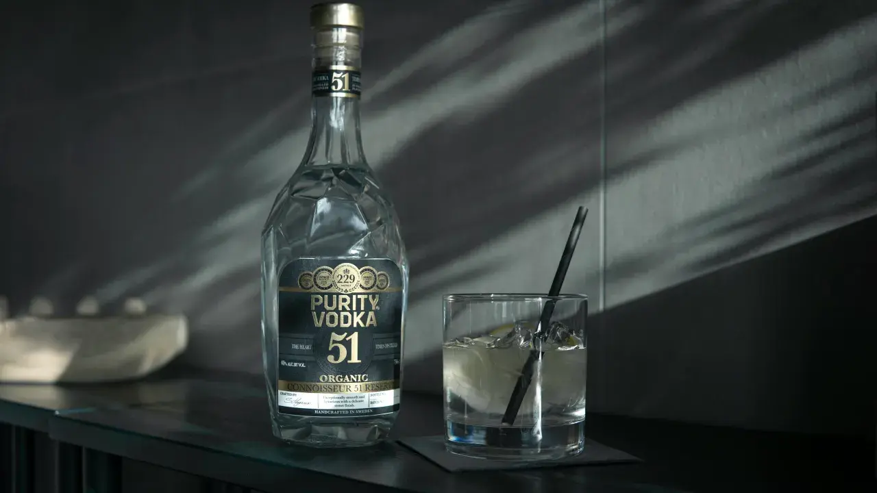 Butelka Purity Vodka i szklanka z drinkiem. Wódka, okowita i bimber – definicje prawne.