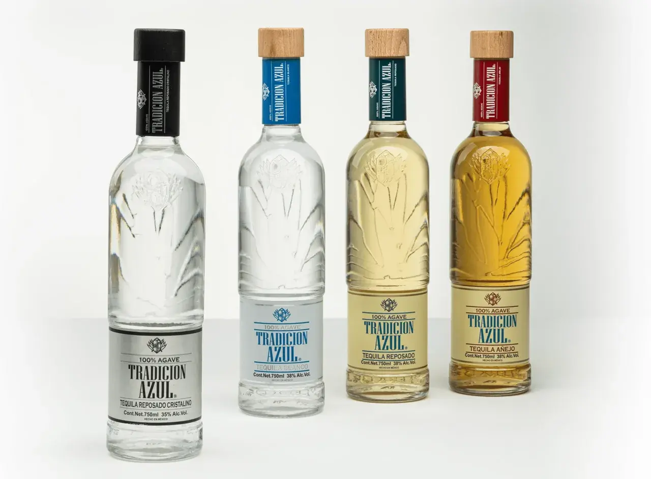 Cztery butelki tequili Tradicion Azul: blanco, reposado cristalino, reposado i añejo. Różnica między tequilą blanco, reposado a añejo w smaku i cenie jest widoczna w kolorze i etykietach.