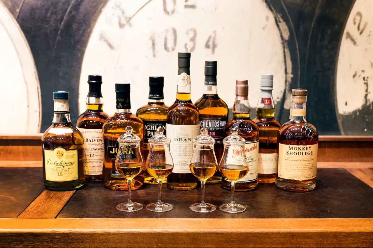Rząd butelek whisky, w tym Dalwhinnie 15, Balvenie 12, Jura, Oban, Glenmorangie, Monkey Shoulder. Czy warto kupować whisky bez określenia wieku (NAS)?
