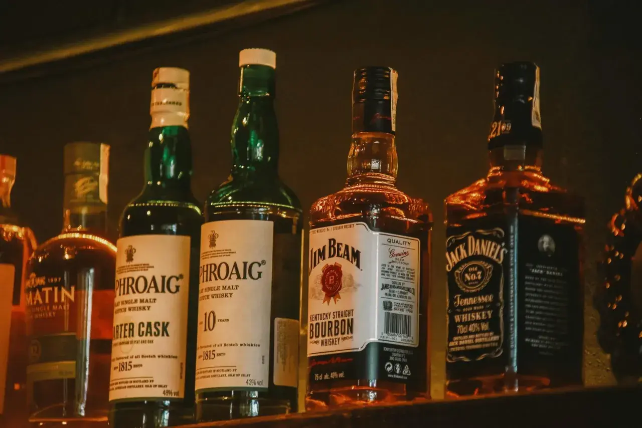 Butelki whisky: różnice w kolorze, od naturalnej barwy po karmel E150a.