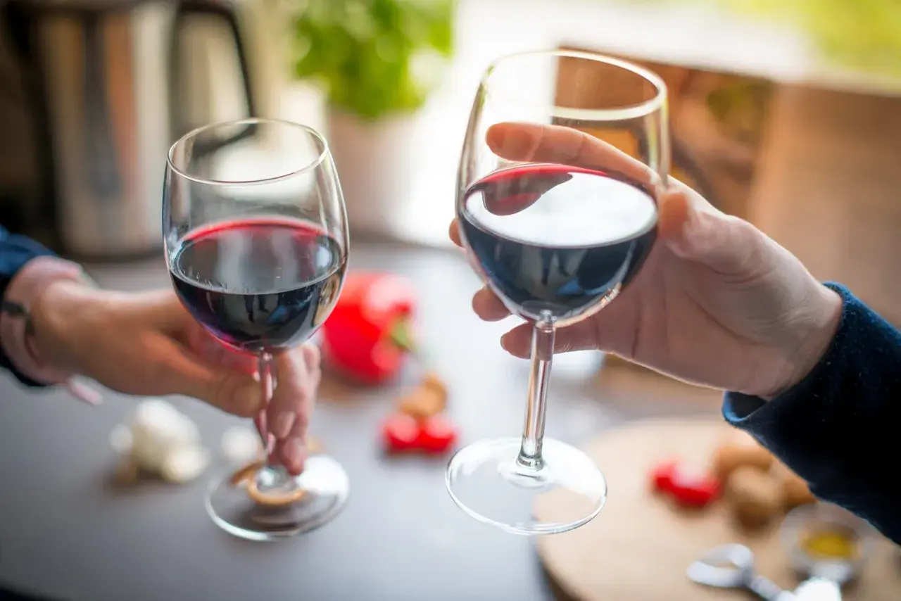Skutki zbyt wysokiej temperatury serwowania: czerwone wino grzać nie warto, bo traci smak. Dwie kieliszki wina.