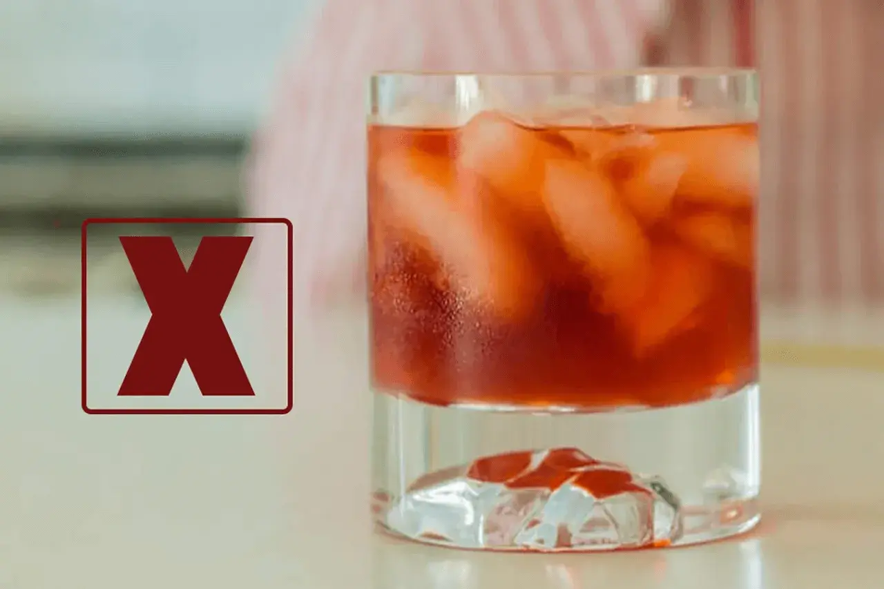 Czerwony znak "X" obok drinka z lodem. Dlaczego negroni musi być mieszane, a nie wstrząsane w shakerze, by zachować idealny smak.