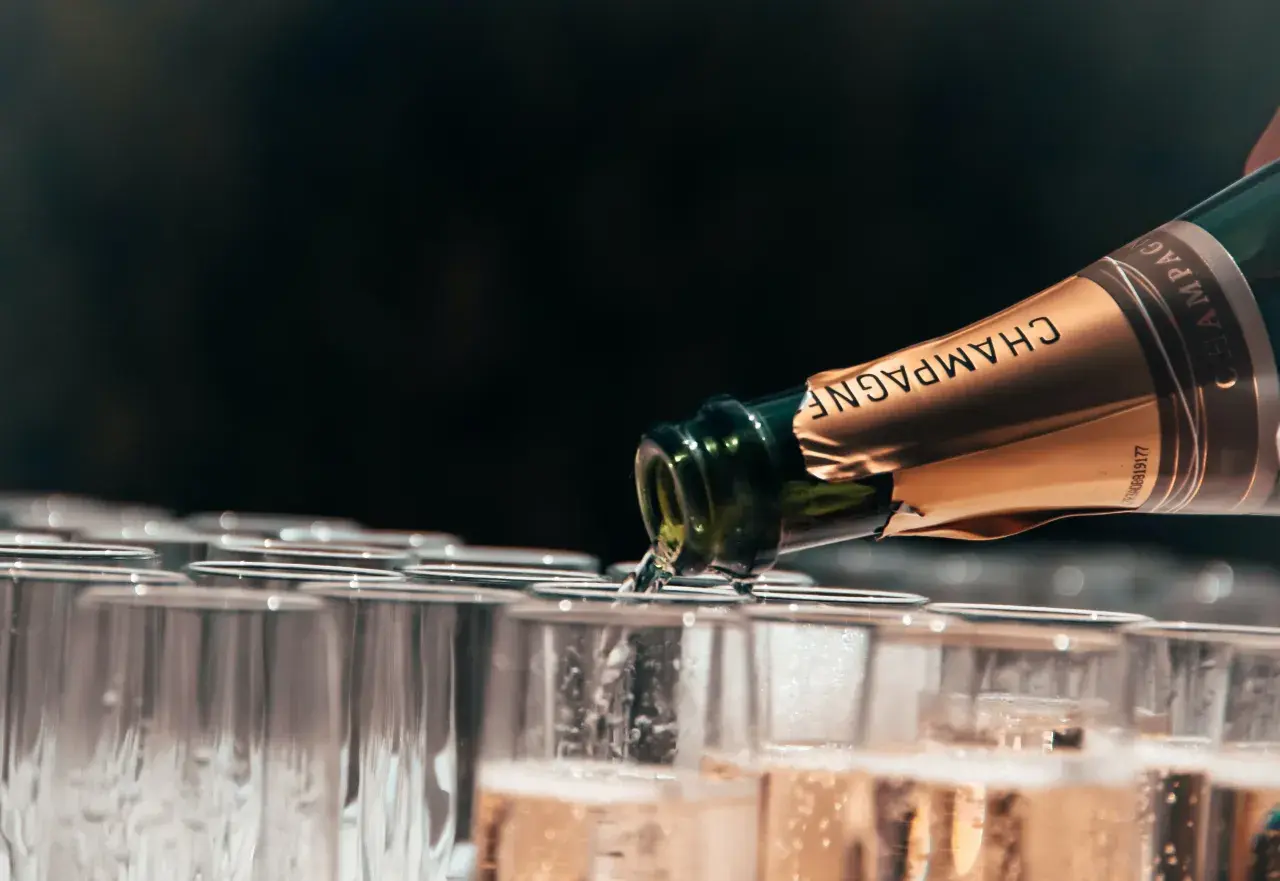 Szampan nalewany do kieliszków. Dlaczego wino musujące typu Prosecco jest tańsze od Szampana? Różnice w metodach produkcji i pochodzeniu.