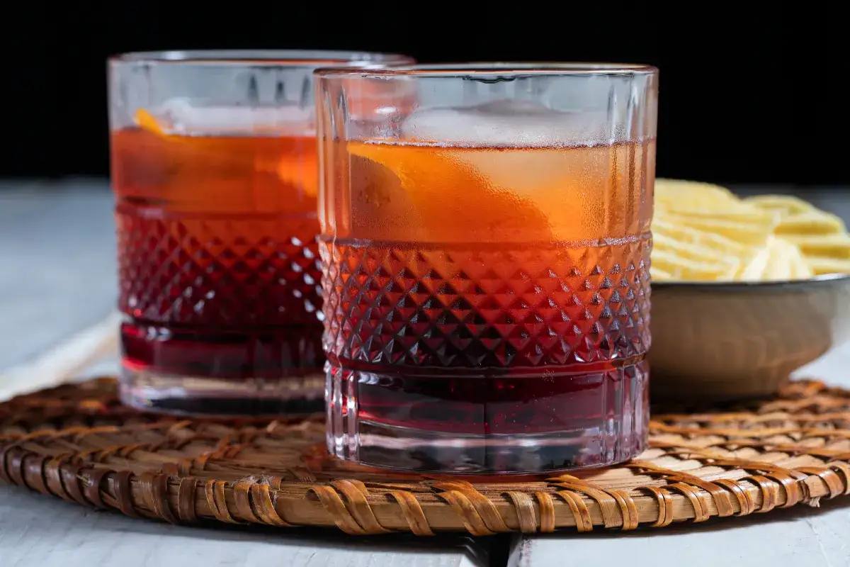 Dwa negroni z lodem i skórką pomarańczy, idealnie mieszane, by zachować balans smaku. Dlaczego negroni musi być mieszane a nie wstrząsane w shakerze? Bo tak jest najlepiej!