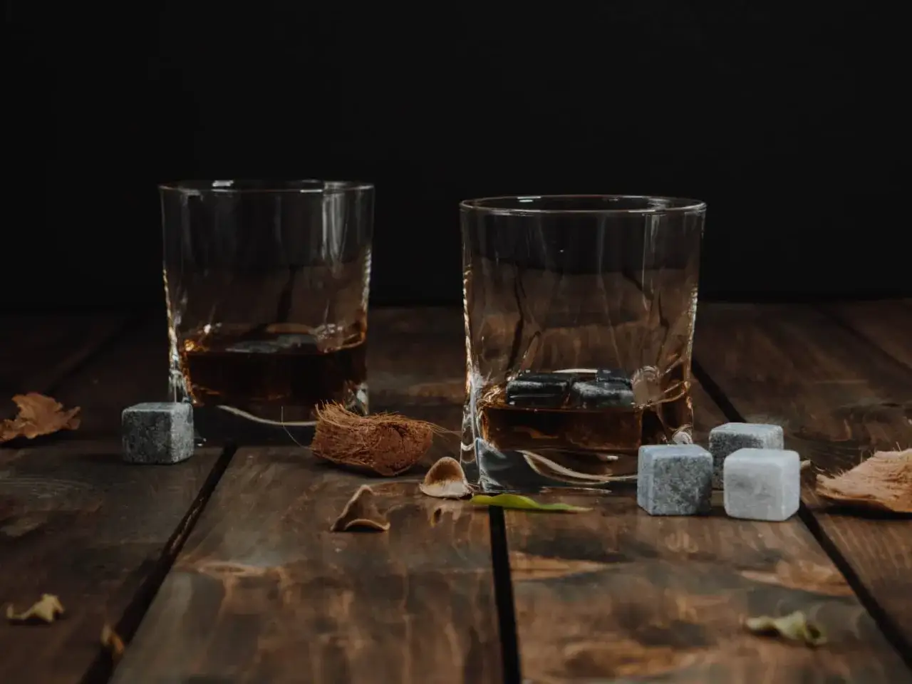 Dwa kieliszki whisky z kamieniami chłodzącymi. Pokazują, dlaczego kości chłodzące są lepsze od lodu.