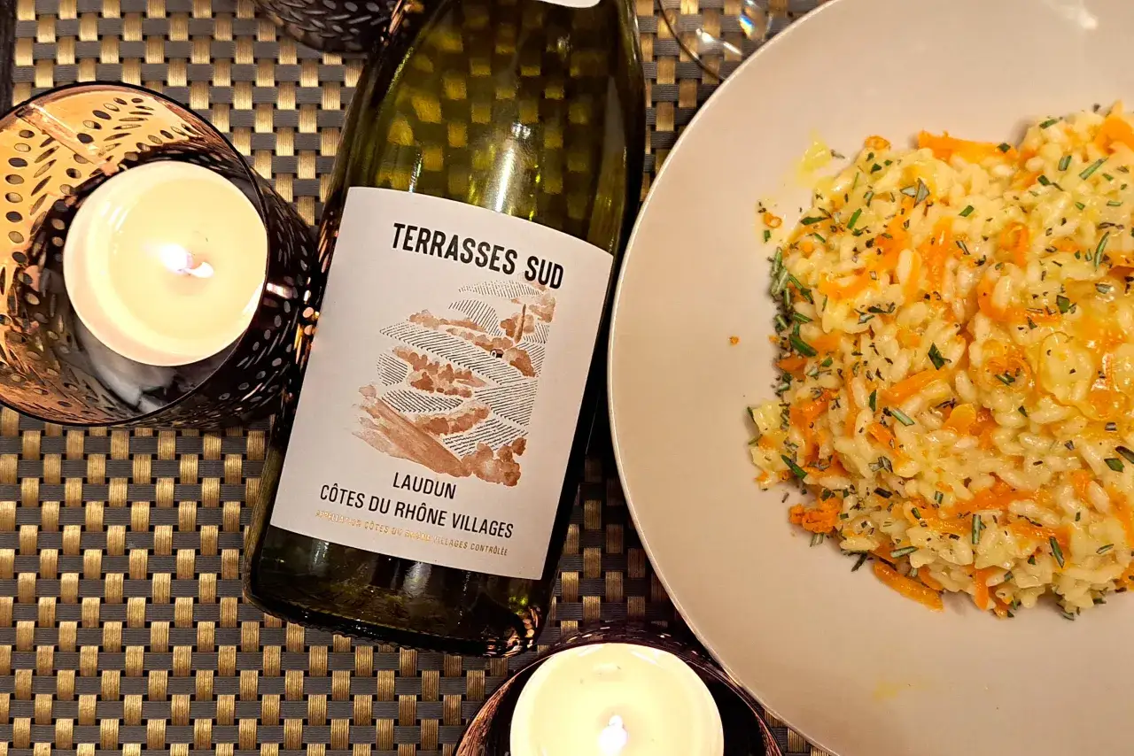 Butelka wina i talerz risotto z marchewką. Czy warto mrozić wino do późniejszego wykorzystania w kuchni?