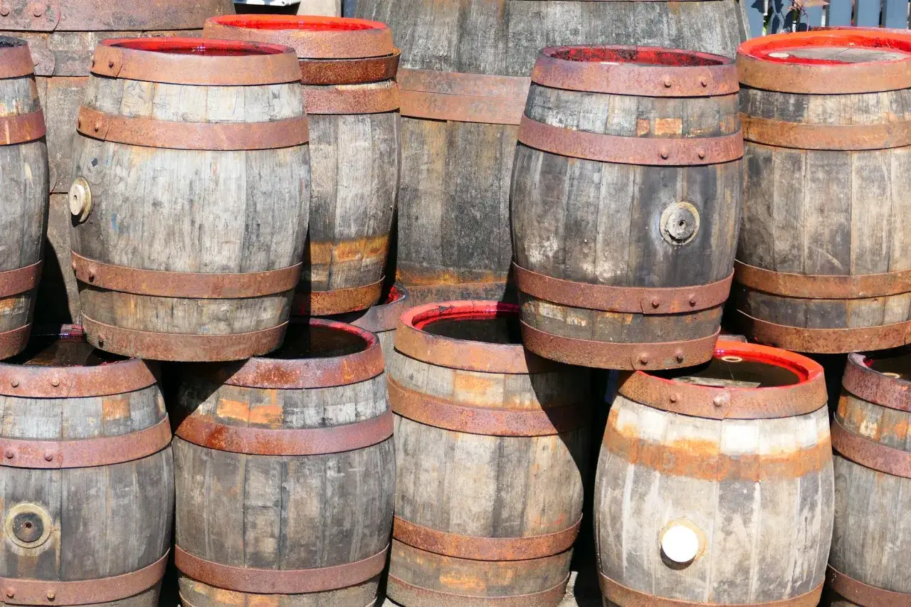Stare beczki z whisky. Metaliczny posmak i pieczenie to objawy niskiej jakości whisky zbożowej.