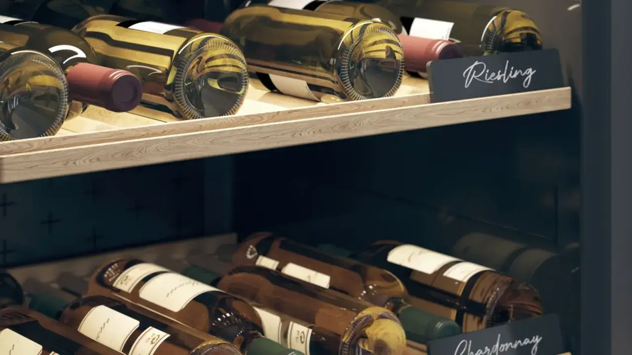Odkryj najlepsze techniki przechowywania otwartego wina, by przedłużyć jego trwałość. Na półkach winiarki stoją butelki Riesling i Chardonnay.
