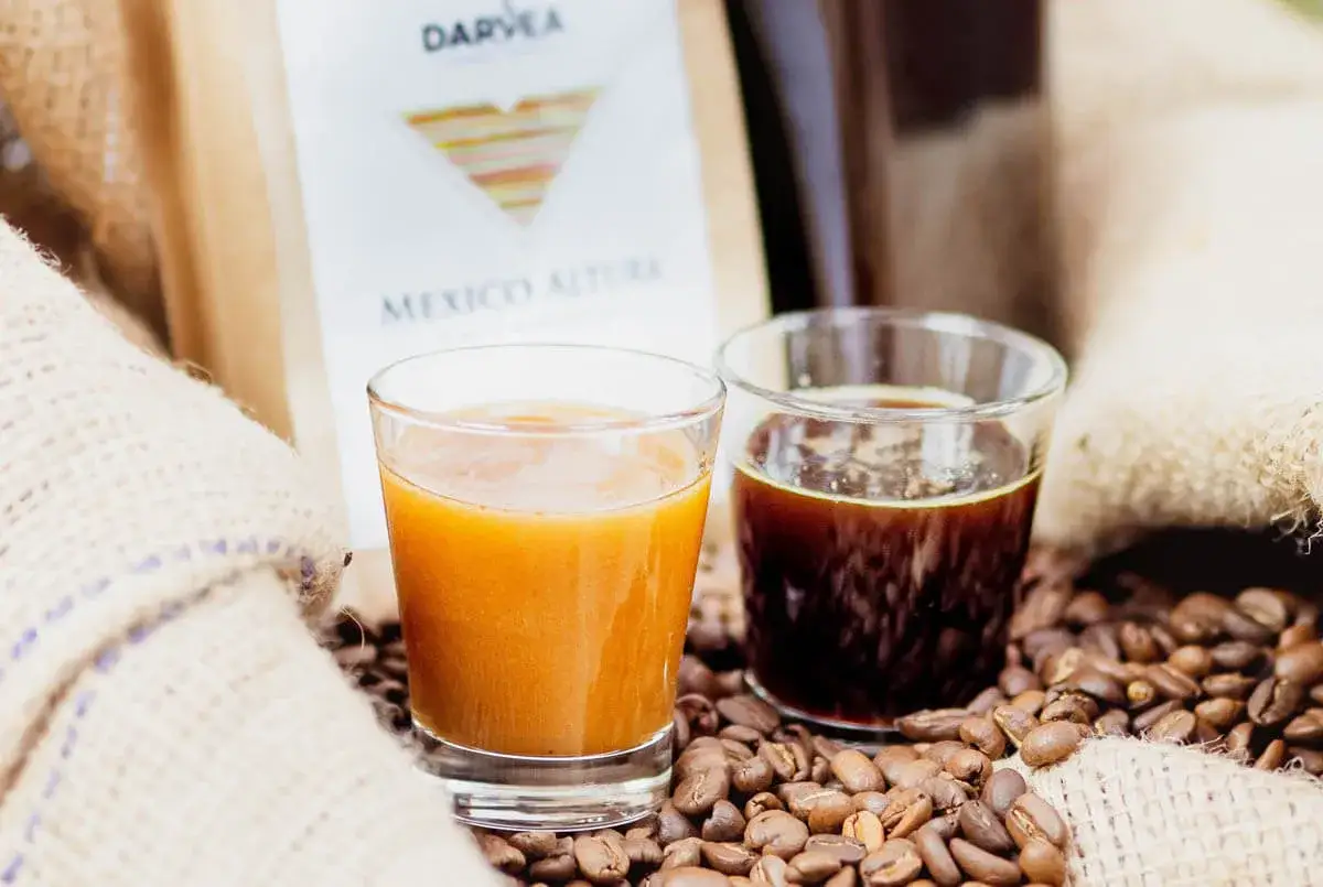 Domowy likier kawowy typu Kahlua w 15 minut? Dwa kieliszki z kawą i słodkim likierem, ziarna kawy i torba z napisem