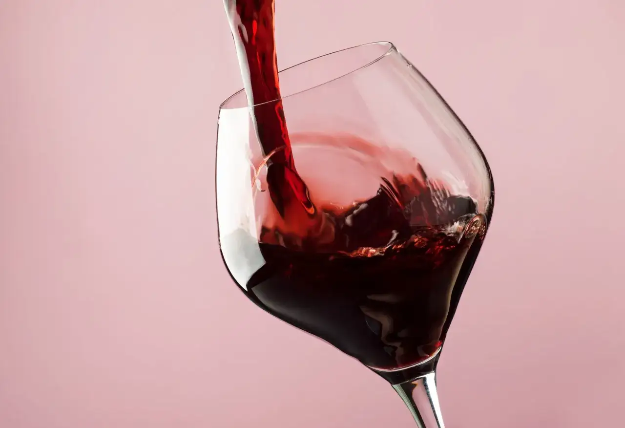 Czerwone wino nalewane do kieliszka. Czy siarczyny czy taniny bardziej szkodzą i powodują ból głowy po winie?