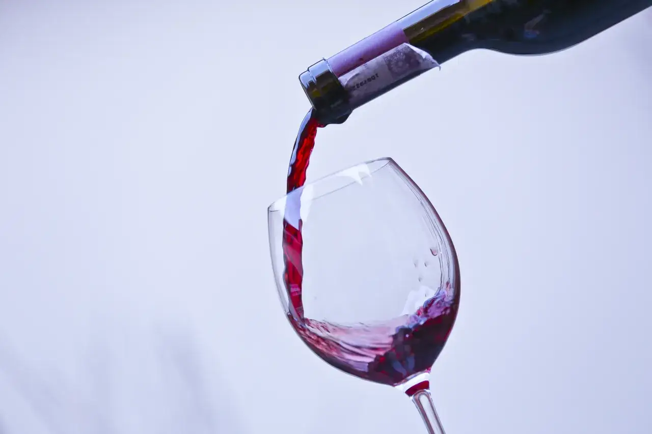 Czerwone wino nalewane do kieliszka. Czy siarczyny czy taniny bardziej szkodzą i powodują ból głowy po winie?