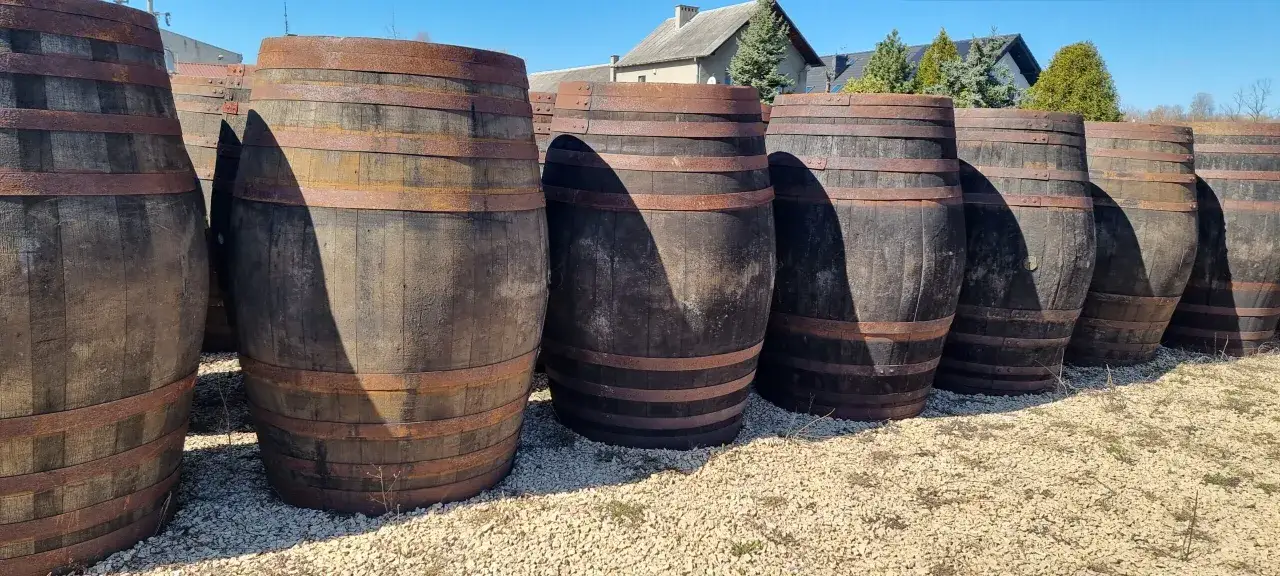 Drewniane beczki stojące w rzędzie. Mogą być przyczyną objawów przesycenia dębem w whisky, zbyt gorzkiego i ściągającego finiszu.