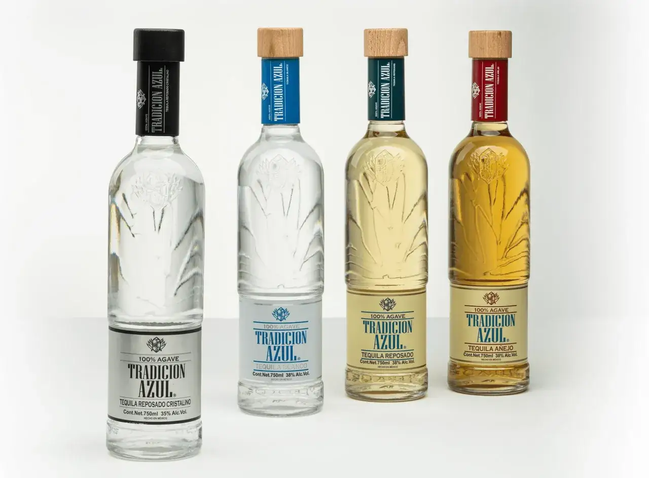 Cztery butelki tequili Tradicion Azul: Blanco, Reposado Cristalino, Reposado i Añejo. Różnica między tequilą blanco reposado a anejo w smaku i cenie jest widoczna w kolorze i wieku leżakowania.