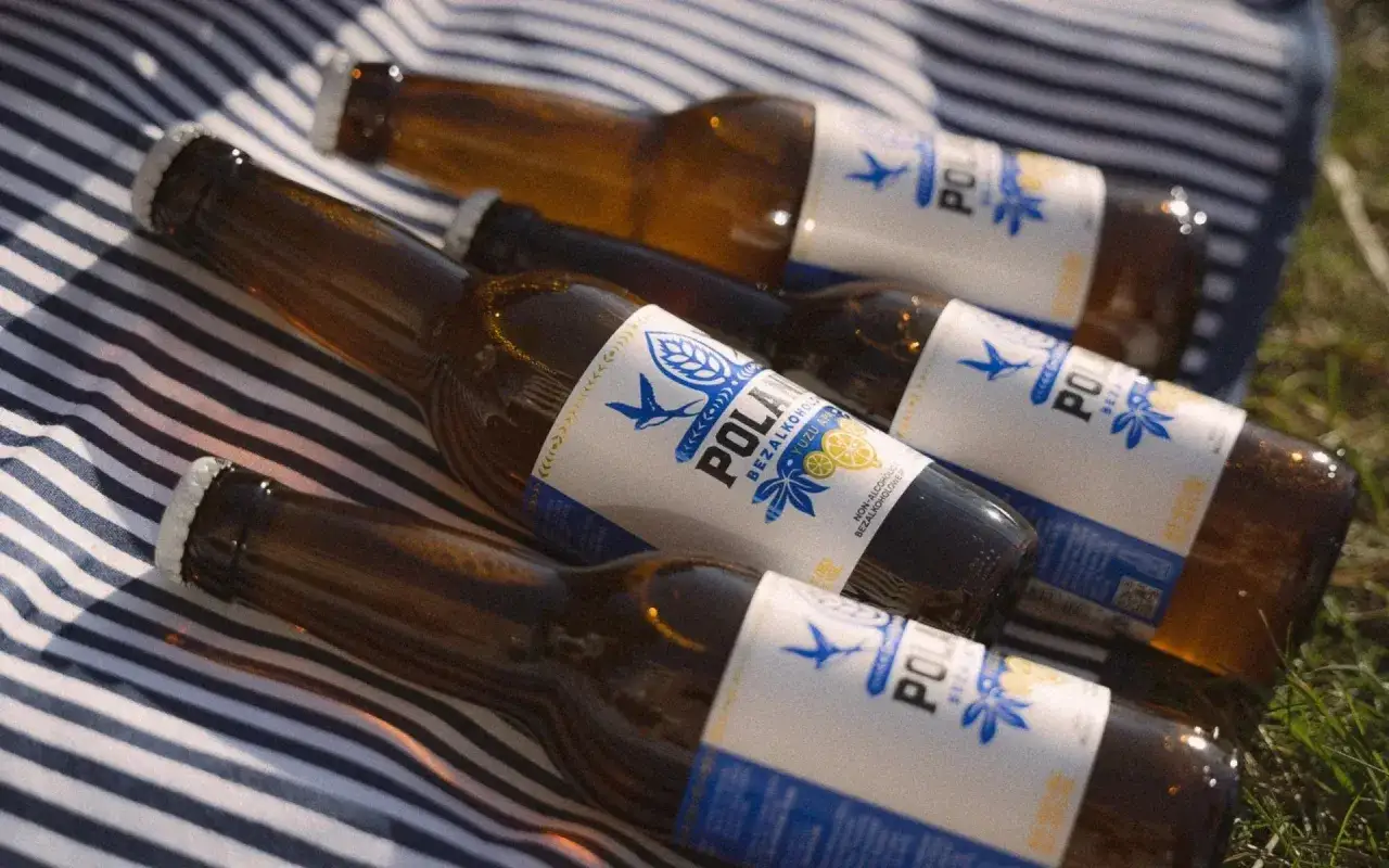 Butelki piwa bezalkoholowego na kocyku. Czy piwo odwadnia? To pytanie pozostaje otwarte, ale te butelki wyglądają orzeźwiająco.