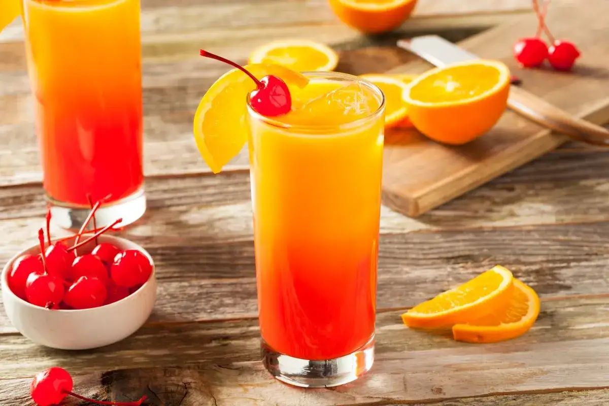 Jak zrobić drinki z tequilą inne niż margarita? Inspiracje 2026: Tequila Sunrise z pomarańczą i wiśnią.